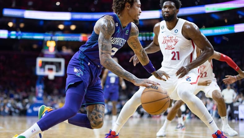 Dec 11, 2022; Philadelphia, Pennsylvania, USA; Charlotte Hornets guard Kelly Oubre Jr. (12) drives against Philadelphia 76ers center Joel Embiid (21) during the first quarter at Wells Fargo Center. Mandatory Credit: Bill Streicher-USA TODAY Sports