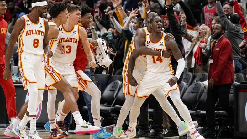 Dec 11, 2022; Atlanta, Georgia, USA; Atlanta Hawks forward AJ Griffin (14) reacts with teammates after making a shot at the buzzer to defeat the Chicago Bulls in overtime at State Farm Arena. Mandatory Credit: Dale Zanine-USA TODAY Sports
