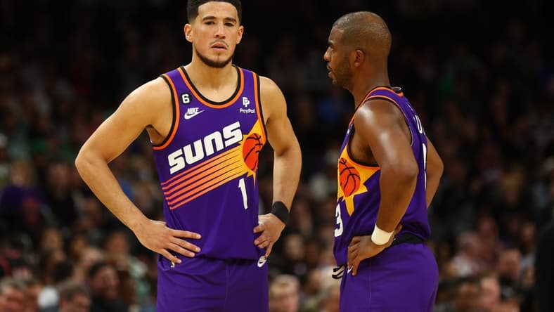 Dec 7, 2022; Phoenix, Arizona, USA; Phoenix Suns guard Devin Booker (1) and Chris Paul (3) against the Boston Celtics at Footprint Center. Mandatory Credit: Mark J. Rebilas-USA TODAY Sports