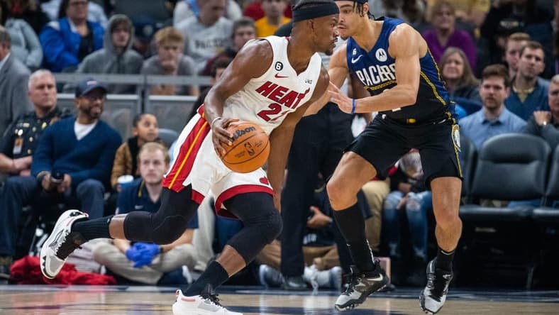 Dec 12, 2022; Indianapolis, Indiana, USA; Miami Heat forward Jimmy Butler (22) dribbles the ball while Indiana Pacers guard Andrew Nembhard (2) defends in the second quarter at Gainbridge Fieldhouse. Mandatory Credit: Trevor Ruszkowski-USA TODAY Sports
