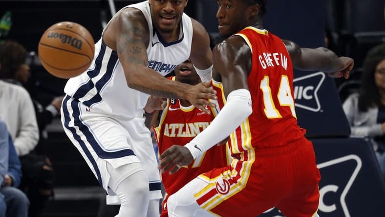 Dec 12, 2022; Memphis, Tennessee, USA; Memphis Grizzlies forward Xavier Tillman (left) and Atlanta Hawks forward AJ Griffin (14) battle for a a loose ball during the first half at FedExForum. Mandatory Credit: Petre Thomas-USA TODAY Sports