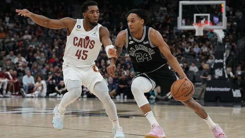 Dec 12, 2022; San Antonio, Texas, USA; San Antonio Spurs guard Devin Vassell (24) dribbles past Cleveland Cavaliers guard Donovan Mitchell (45) in the first half at the AT&T Center. Mandatory Credit: Daniel Dunn-USA TODAY Sports