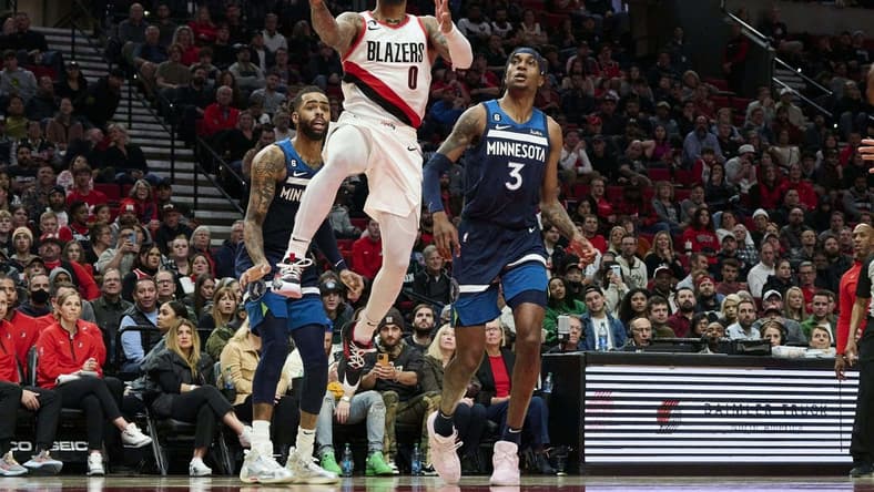 Dec 12, 2022; Portland, Oregon, USA;  Portland Trail Blazers guard Damian Lillard (0) scores a basket during the first half against Minnesota Timberwolves forward Jaden McDaniels (3) at Moda Center. Mandatory Credit: Troy Wayrynen-USA TODAY Sports