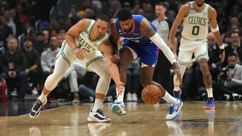 Dec 12, 2022; Los Angeles, California, USA; Boston Celtics guard Malcolm Brogdon (left) and guard Paul George (13) reach for the ball in the first half at Crypto.com Arena. Mandatory Credit: Kirby Lee-USA TODAY Sports