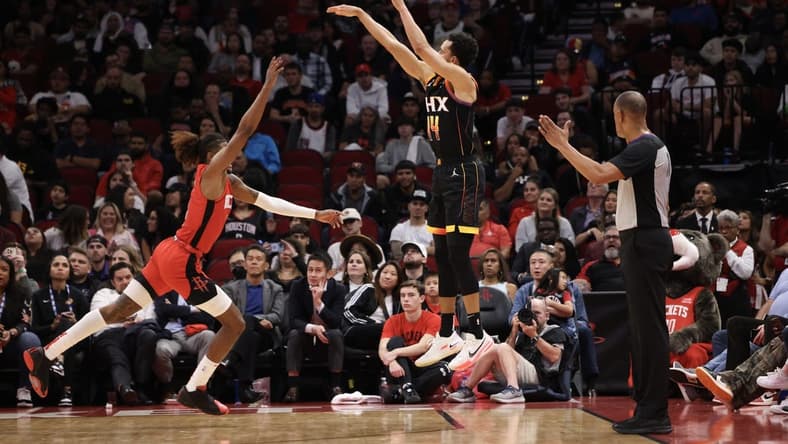 zDec 13, 2022; Houston, Texas, USA; Phoenix Suns guard Landry Shamet (14) makes a three point basket against Houston Rockets guard Jalen Green (4) in the second half at Toyota Center. Mandatory Credit: Thomas Shea-USA TODAY Sports