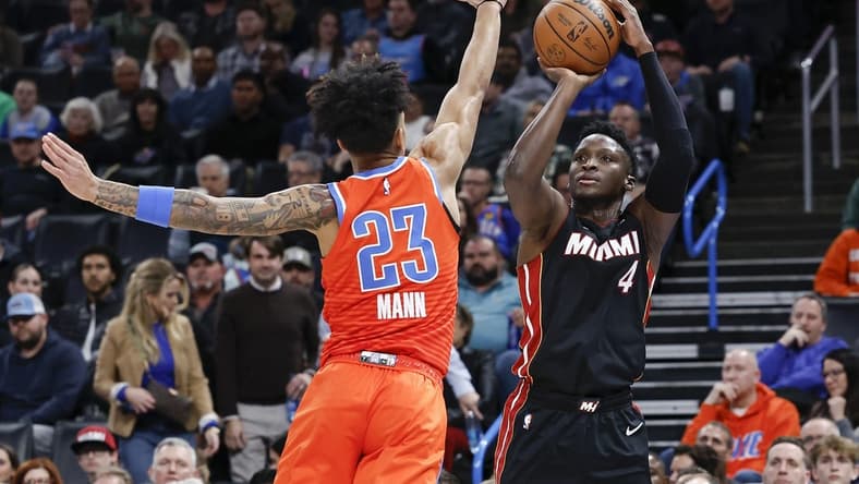 Dec 14, 2022; Oklahoma City, Oklahoma, USA; Miami Heat guard Victor Oladipo (4) shoots over Oklahoma City Thunder guard Tre Mann (23) during the second quarter at Paycom Center. Mandatory Credit: Alonzo Adams-USA TODAY Sports
