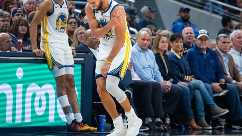 Dec 14, 2022; Indianapolis, Indiana, USA; Golden State Warriors guard Stephen Curry (30) grabs his shoulder in the second half against the Indiana Pacers at Gainbridge Fieldhouse. Mandatory Credit: Trevor Ruszkowski-USA TODAY Sports