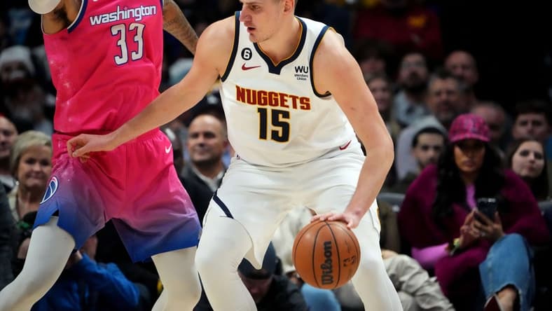 Dec 14, 2022; Denver, Colorado, USA; Denver Nuggets center Nikola Jokic (15) dribbles from Washington Wizards forward Kyle Kuzma (33) in the second quarter at Ball Arena. Mandatory Credit: Ron Chenoy-USA TODAY Sports