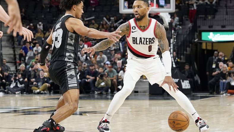 Dec 14, 2022; San Antonio, Texas, USA; Portland Trailblazers guard Damian Lillard (0) looks to the pass the ball while defended by San Antonio Spurs guard Tre Jones (33) during the second half at AT&T Center. Mandatory Credit: Scott Wachter-USA TODAY Sports
