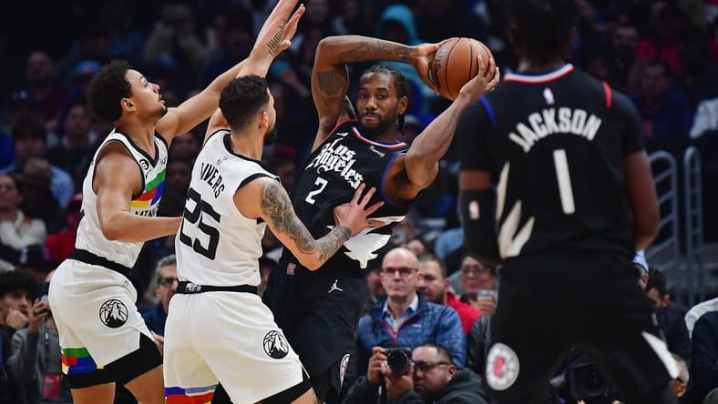 Dec 14, 2022; Los Angeles, California, USA; Los Angeles Clippers forward Kawhi Leonard (2) controls the ball against Minnesota Timberwolves guard Bryn Forbes (10) and guard Austin Rivers (25) during the first half at Crypto.com Arena. Mandatory Credit: Gary A. Vasquez-USA TODAY Sports