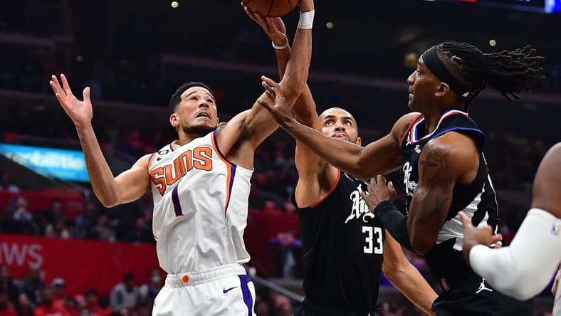 Dec 15, 2022; Los Angeles, California, USA; Phoenix Suns guard Devin Booker (1) plays for the rebound against Los Angeles Clippers forward Nicolas Batum (33) and guard Terance Mann (14) during the first half at Crypto.com Arena. Mandatory Credit: Gary A. Vasquez-USA TODAY Sports