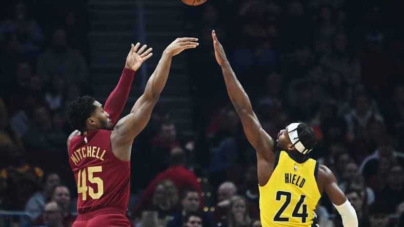 Dec 16, 2022; Cleveland, Ohio, USA; Cleveland Cavaliers guard Donovan Mitchell (45) shoots over the defense of Indiana Pacers guard Buddy Hield (24) during the first half at Rocket Mortgage FieldHouse. Mandatory Credit: Ken Blaze-USA TODAY Sports