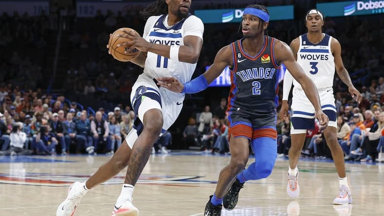 Dec 16, 2022; Oklahoma City, Oklahoma, USA; Minnesota Timberwolves center Naz Reid (11) drives to the basket against Oklahoma City Thunder guard Shai Gilgeous-Alexander (2) during the first quarter at Paycom Center. Mandatory Credit: Alonzo Adams-USA TODAY Sports