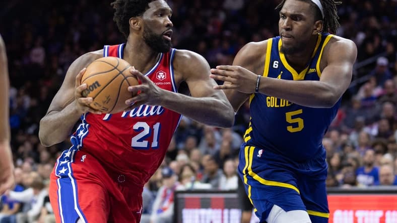 Dec 16, 2022; Philadelphia, Pennsylvania, USA; Philadelphia 76ers center Joel Embiid (21) drives against Golden State Warriors center Kevon Looney (5) during the fourth quarter at Wells Fargo Center. Mandatory Credit: Bill Streicher-USA TODAY Sports