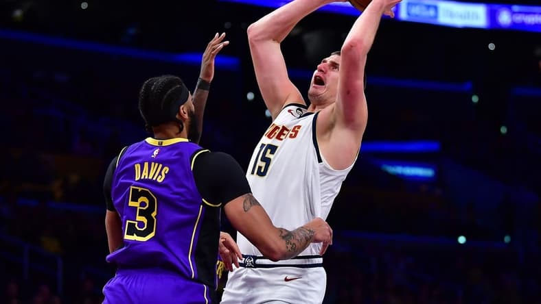 Dec 16, 2022; Los Angeles, California, USA; Denver Nuggets center Nikola Jokic (15) shoots against Los Angeles Lakers forward Anthony Davis (3) during the first half at Crypto.com Arena. Mandatory Credit: Gary A. Vasquez-USA TODAY Sports