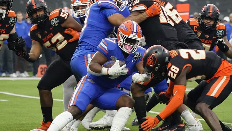 Dec 17, 2022; Las Vegas, NV, USA; Florida Gators running back Trevor Etienne (7) runs with the ball through the Oregon State Beavers defense during the first half at the Las Vegas Bowl at Allegiant Stadium. Mandatory Credit: Lucas Peltier-USA TODAY Sports