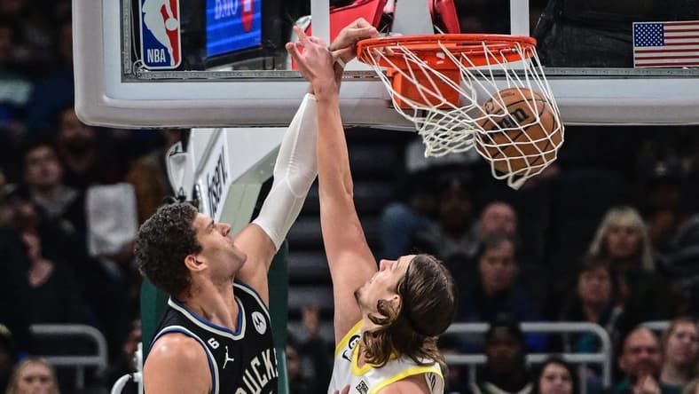 Dec 17, 2022; Milwaukee, Wisconsin, USA; Milwaukee Bucks center Brook Lopez (11)  dunks against Utah Jazz guard Mike Conley (11) in the first quarter at Fiserv Forum. Mandatory Credit: Benny Sieu-USA TODAY Sports