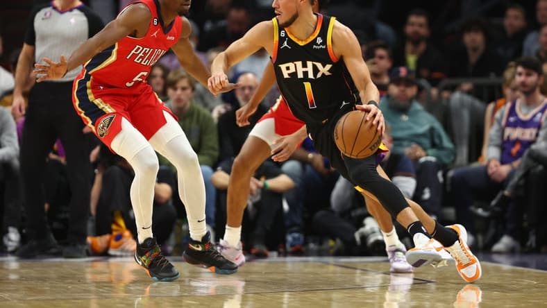 Dec 17, 2022; Phoenix, Arizona, USA; Phoenix Suns guard Devin Booker (1) against New Orleans Pelicans forward Herbert Jones in the first half at Footprint Center. Mandatory Credit: Mark J. Rebilas-USA TODAY Sports