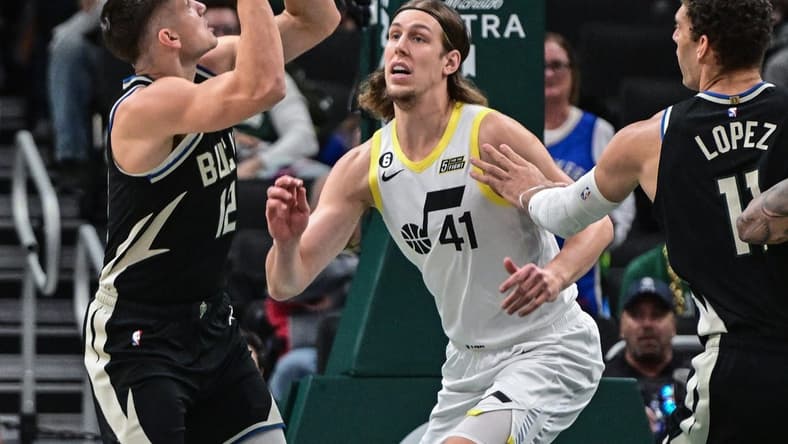 Dec 17, 2022; Milwaukee, Wisconsin, USA; Milwaukee Bucks guard Grayson Allen (12) shoots the ball against Utah Jazz forward Kelly Olynyk (41) in the first quarter at Fiserv Forum. Mandatory Credit: Benny Sieu-USA TODAY Sports