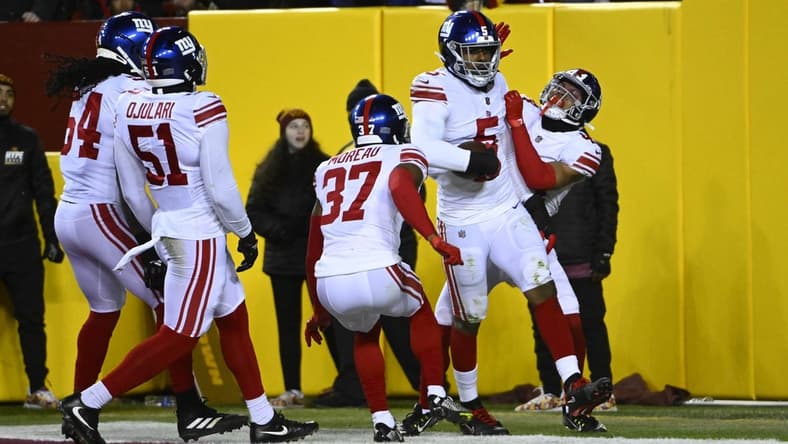 Dec 18, 2022; Landover, Maryland, USA; New York Giants defensive end Kayvon Thibodeaux (5) is congratulated by teammates after scoring a touchdown against the Washington Commanders during the first half at FedExField. Mandatory Credit: Brad Mills-USA TODAY Sports