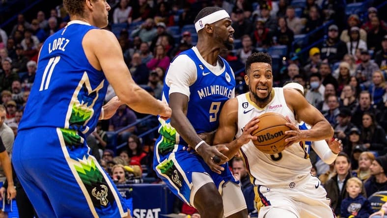 Dec 19, 2022; New Orleans, Louisiana, USA; New Orleans Pelicans guard CJ McCollum (3) dribbles against Milwaukee Bucks forward Bobby Portis (9) and center Brook Lopez (11) during the first half at Smoothie King Center. Mandatory Credit: Stephen Lew-USA TODAY Sports