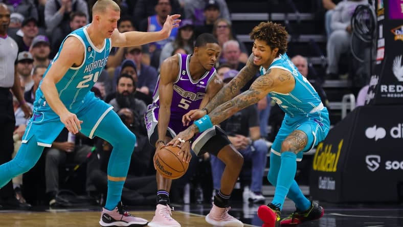 Dec 19, 2022; Sacramento, California, USA; Charlotte Hornets guard Kelly Oubre Jr. (12) steals the ball from Sacramento Kings guard De'Aaron Fox (5) during the first quarter at Golden 1 Center. Mandatory Credit: Sergio Estrada-USA TODAY Sports