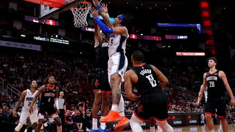 Dec 21, 2022; Houston, Texas, USA; Orlando Magic forward Paolo Banchero (5) makes a layup while Houston Rockets forward Jabari Smith Jr. (1) defends during the fourth quarter at Toyota Center. Mandatory Credit: Erik Williams-USA TODAY Sports