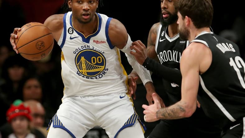 Dec 21, 2022; Brooklyn, New York, USA; Golden State Warriors forward Jonathan Kuminga (00) controls the ball against Brooklyn Nets forward Royce O'Neale (00) and forward Joe Harris (12) during the third quarter at Barclays Center. Mandatory Credit: Brad Penner-USA TODAY Sports