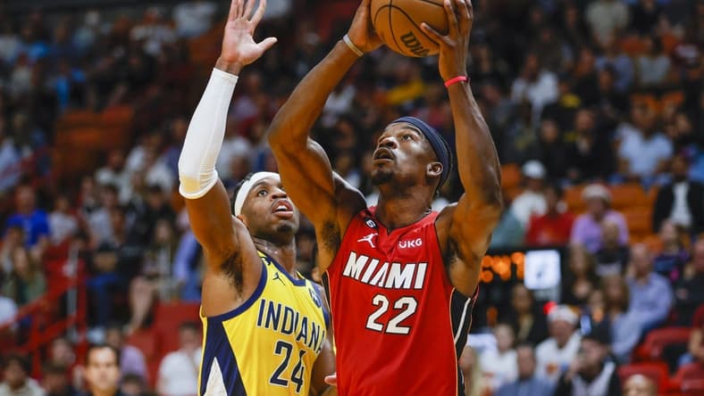 Dec 23, 2022; Miami, Florida, USA; Miami Heat forward Jimmy Butler (22) protects the ball from Indiana Pacers guard Buddy Hield (24) during the first quarter at FTX Arena. Mandatory Credit: Sam Navarro-USA TODAY Sports
