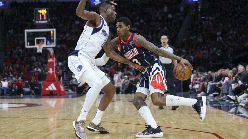 Dec 23, 2022; Houston, Texas, USA; Houston Rockets guard Kevin Porter Jr. (3) dribbles the ball as Dallas Mavericks forward Reggie Bullock (25) defends during the second quarter at Toyota Center. Mandatory Credit: Troy Taormina-USA TODAY Sports