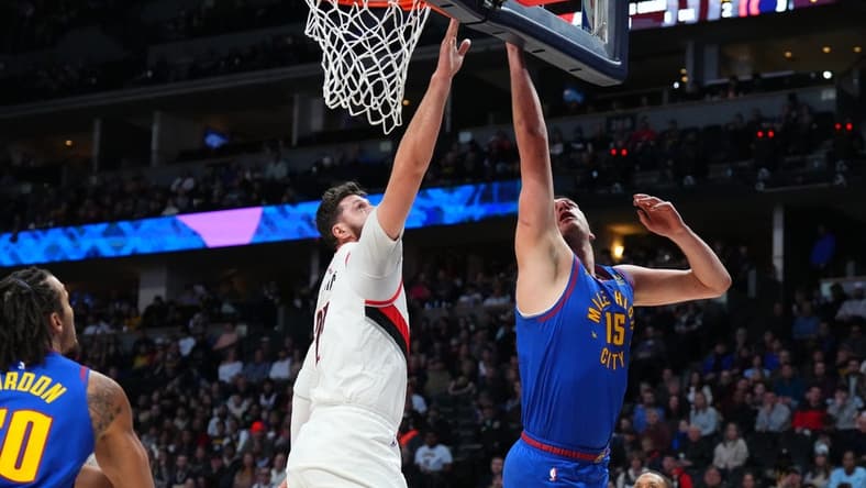 Dec 23, 2022; Denver, Colorado, USA; Denver Nuggets center Nikola Jokic (15) shoots past Portland Trail Blazers center Jusuf Nurkic (27) in the first quarter at Ball Arena. Mandatory Credit: Ron Chenoy-USA TODAY Sports