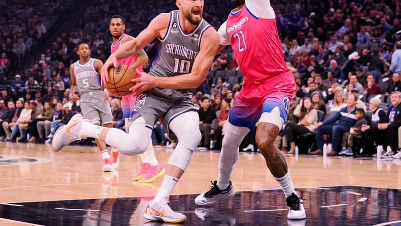 Dec 23, 2022; Sacramento, California, USA; Sacramento Kings power forward Domantas Sabonis (10) drives in against Washington Wizards center Daniel Gafford (21) during the first quarter at Golden 1 Center. Mandatory Credit: Kelley L Cox-USA TODAY Sports
