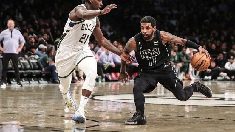 Dec 23, 2022; Brooklyn, New York, USA; Brooklyn Nets guard Kyrie Irving (11) drives past Milwaukee Bucks guard Jrue Holiday (21) in the third quarter at Barclays Center. Mandatory Credit: Wendell Cruz-USA TODAY Sports
