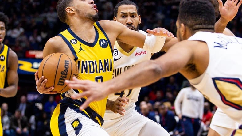 Dec 26, 2022; New Orleans, Louisiana, USA; Indiana Pacers guard Tyrese Haliburton (0) drives to the basket against New Orleans Pelicans forward Garrett Temple (41) and guard CJ McCollum (3) during the first half at Smoothie King Center. Mandatory Credit: Stephen Lew-USA TODAY Sports