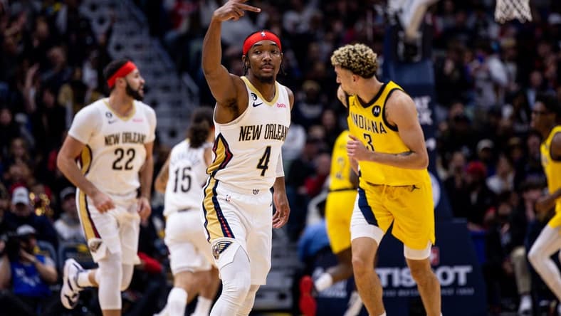 Dec 26, 2022; New Orleans, Louisiana,  USA;  New Orleans Pelicans guard Devonte' Graham (4) reacts to making a three point basket against Indiana Pacers guard Chris Duarte (3) during the first half at Smoothie King Center. Mandatory Credit: Stephen Lew-USA TODAY Sports