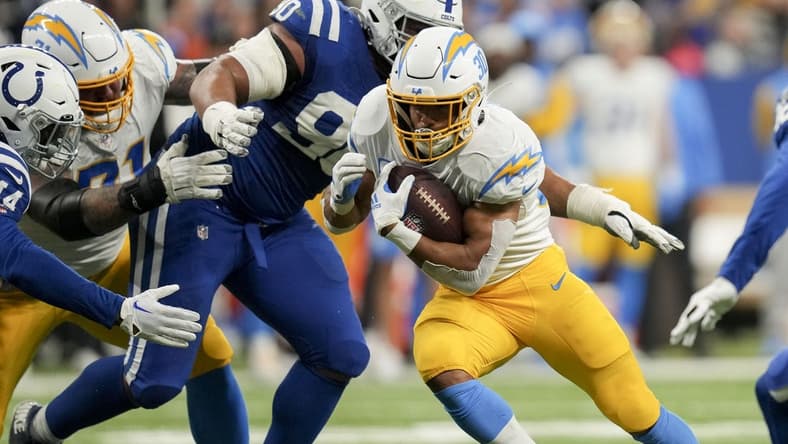 Dec 26, 2022; Indianapolis, Indiana, USA; Los Angeles Chargers running back Austin Ekeler (30) moves past Indianapolis Colts defensive tackle Grover Stewart (90) on Monday, Dec. 26, 2022, during a game against the Los Angeles Chargers at Lucas Oil Stadium in Indianapolis. Mandatory Credit: Jenna Watson-USA TODAY Sports
