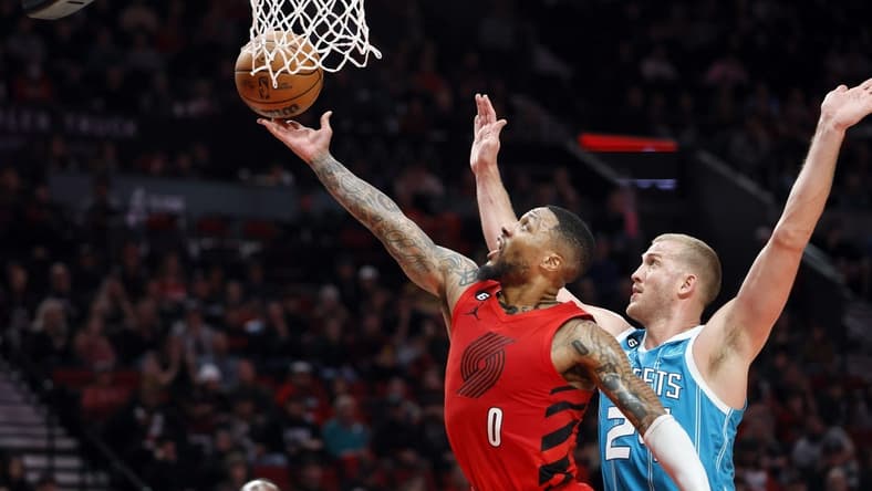 Dec 26, 2022; Portland, Oregon, USA; Portland Trail Blazers point guard Damian Lillard (0) shoots the ballast Charlotte Hornets center Mason Plumlee (24) during the first half at Moda Center. Mandatory Credit: Soobum Im-USA TODAY Sports