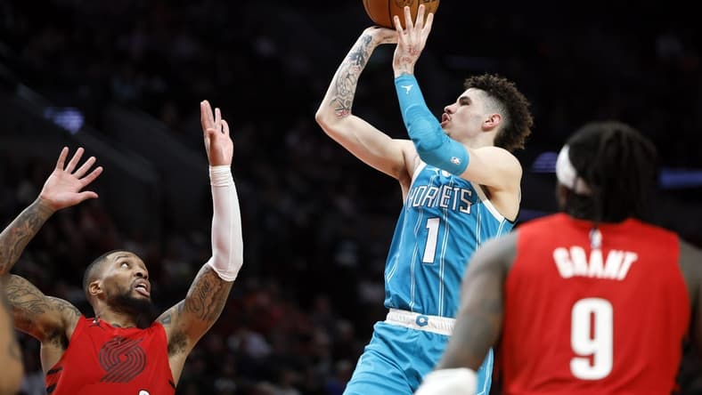 Dec 26, 2022; Portland, Oregon, USA; Charlotte Hornets point guard LaMelo Ball (1) shoots the ball over Portland Trail Blazers point guard Damian Lillard (0, left) during the second half at Moda Center. Mandatory Credit: Soobum Im-USA TODAY Sports