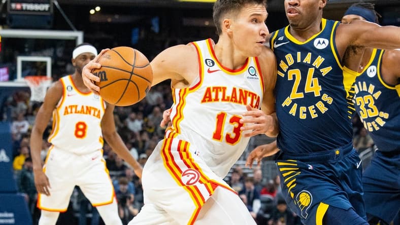 Dec 27, 2022; Indianapolis, Indiana, USA; Atlanta Hawks guard Bogdan Bogdanovic (13) dribbles the ball while Indiana Pacers guard Buddy Hield (24) defends in the first quarter at Gainbridge Fieldhouse. Mandatory Credit: Trevor Ruszkowski-USA TODAY Sports