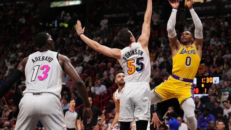 Dec 28, 2022; Miami, Florida, USA; Los Angeles Lakers guard Russell Westbrook (0) shoots around Miami Heat forward Duncan Robinson (55) during the first half at FTX Arena. Mandatory Credit: Jasen Vinlove-USA TODAY Sports