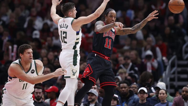 Dec 28, 2022; Chicago, Illinois, USA; Chicago Bulls forward DeMar DeRozan (11) passes the ball away from Milwaukee Bucks guard Grayson Allen (12) during the first half at United Center. Mandatory Credit: Kamil Krzaczynski-USA TODAY Sports