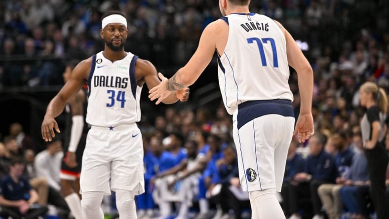Dec 29, 2022; Dallas, Texas, USA; Dallas Mavericks guard Luka Doncic (77) greets guard Kemba Walker (34) as Walker enters the game against the Houston Rockets during the first half at the American Airlines Center. Mandatory Credit: Jerome Miron-USA TODAY Sports