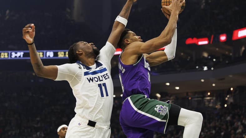 Dec 30, 2022; Milwaukee, Wisconsin, USA; Milwaukee Bucks forward Giannis Antetokounmpo (34) shoots beyond the reach of Minnesota Timberwolves center Naz Reid (11) during the first quarter at Fiserv Forum. Mandatory Credit: Jeff Hanisch-USA TODAY Sports