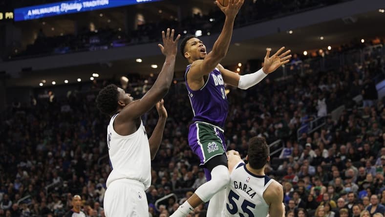 Dec 30, 2022; Milwaukee, Wisconsin, USA; Milwaukee Bucks forward Giannis Antetokounmpo (34) shoots over Minnesota Timberwolves center Luka Garza (55) during the second quarter at Fiserv Forum. Mandatory Credit: Jeff Hanisch-USA TODAY Sports