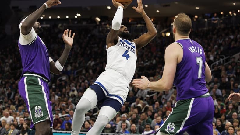 Dec 30, 2022; Milwaukee, Wisconsin, USA;  Minnesota Timberwolves guard Jaylen Nowell (4) shoots between Milwaukee Bucks forward Bobby Portis (9) and forward Joe Ingles (7) during the fourth quarter at Fiserv Forum. Mandatory Credit: Jeff Hanisch-USA TODAY Sports
