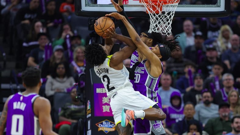 Dec 30, 2022; Sacramento, California, USA; Utah Jazz guard Collin Sexton (2) shoots the ball against Sacramento Kings forward KZ Okpala (30) and center Richaun Holmes (22) during the second quarter at Golden 1 Center. Mandatory Credit: Sergio Estrada-USA TODAY Sports