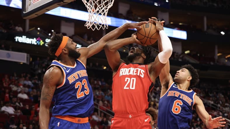Dec 31, 2022; Houston, Texas, USA; Houston Rockets forward Bruno Fernando (20) is fouled by New York Knicks guard Quentin Grimes (6) as center Mitchell Robinson (23) tries to block the shot also in the second quarter at Toyota Center. Mandatory Credit: Thomas Shea-USA TODAY Sports
