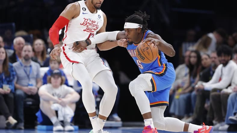 Dec 31, 2022; Oklahoma City, Oklahoma, USA; Oklahoma City Thunder guard Luguentz Dort (5) drives against Philadelphia 76ers forward Tobias Harris (12) during the first quarter at Paycom Center. Mandatory Credit: Alonzo Adams-USA TODAY Sports