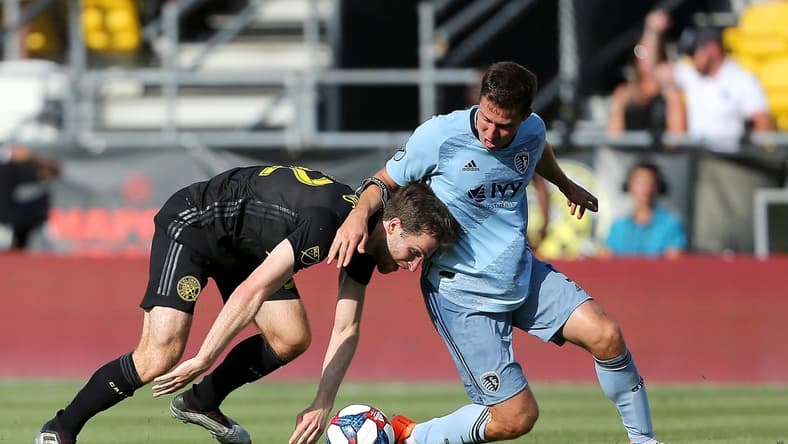 Jun 23, 2019; Columbus, OH, USA;  Columbus Crew forward Patrick Mullins (32) is taken down by Sporting Kansas City defender Matt Besler (5) during the first half at MAPFRE Stadium. Mandatory Credit: Joe Maiorana-USA TODAY Sports
