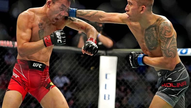 Apr 24, 2021; Jacksonville, Florida, USA; Aoriqileng (Red Gloves) fights Jeff Molina (Blue Gloves) during UFC 261 at VyStar Veterans Memorial Arena. Mandatory Credit: Jasen Vinlove-USA TODAY Sports